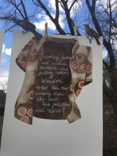 Haiku poem about bird migration during a pandemic, printed on a collage of a shirt with COVID19 virus print.